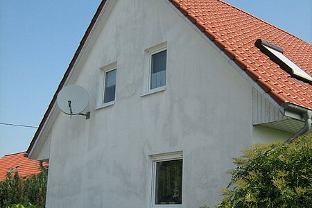 Weißes Einfamilienhaus mit beschmutzter Fassade