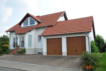Großes Einfamilienhaus mit weißer Fassade und Doppelgarage