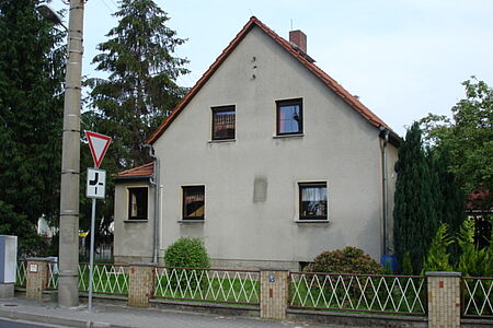 Helles Haus mit kleinem Vorbau und verschmutzter Fassade