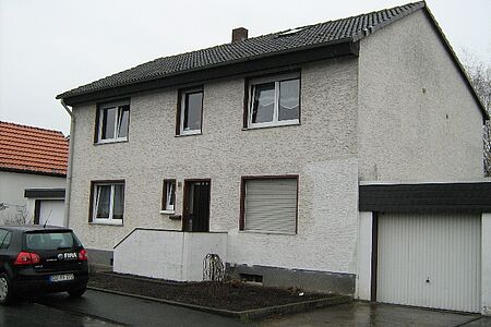 Zweifamilienhaus mit alter, schmutziger Fassade in Weiß