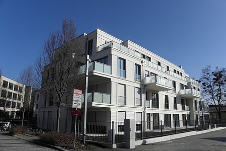 Modernes Mehrfamilienhaus mit großen Fenstern und Balkonen
