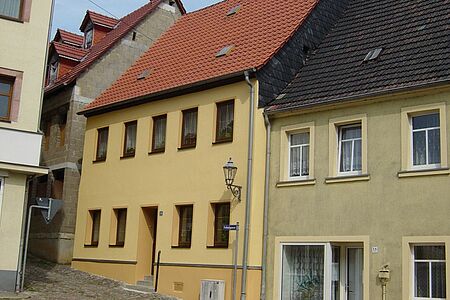 Orangenes Stadthaus in einer schmalen Gasse