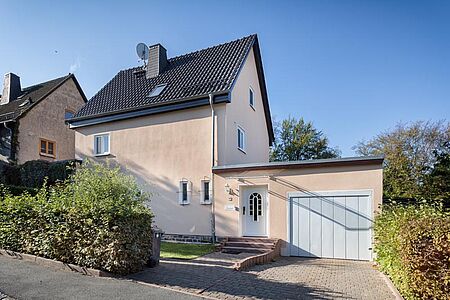 Pastellorange gestrichenes Wohnhaus nach der Sanierung