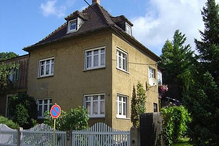 Dreistöckige Villa mit Zeltdach und ockerfarbener Fassade