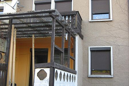 Eingangsbereich eines Hauses mit Wildwuchs