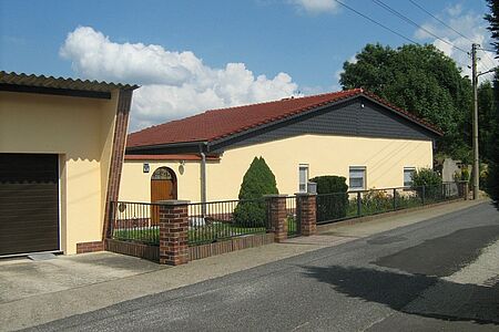 Bungalow mit Satteldach und hellgelber Fassade