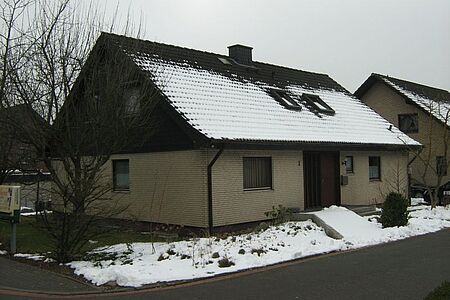 Zweistöckiges Einfamilienhaus mit beige verklinkerter Fassade im Erdgeschoss