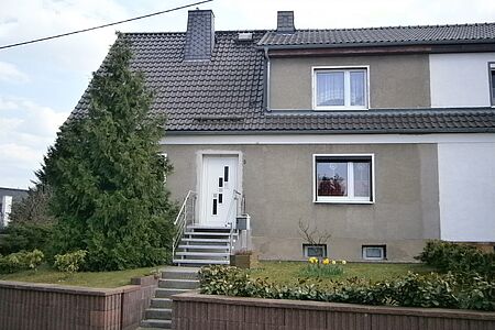 Doppelhaus mit grauer, verputzter Fassade