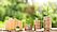 Kleine Holzfigur in Form eines Hauses neben drei Münzstapeln aus denen Pflanzen wachsen