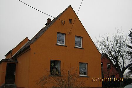 Einfamilienhaus mit veralteter Fassade in schmutzigem Orange