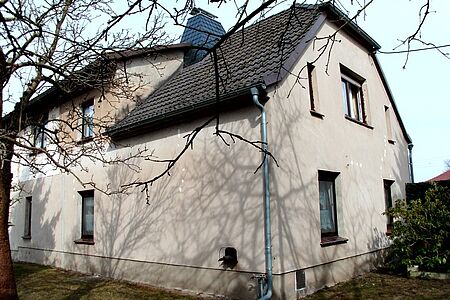 Verblasste und leicht vergilbte Fassade eines Zweifamilienhauses