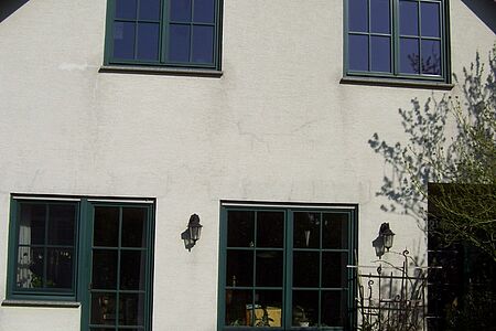 Einfamilienhaus mit fleckiger, rissiger Fassade in Weiß