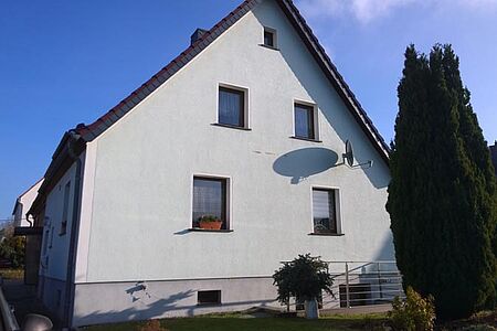 Wohnhaus mit Dach- und Kellergeschoss sowie ebenmäßiger hellblauer Fassade