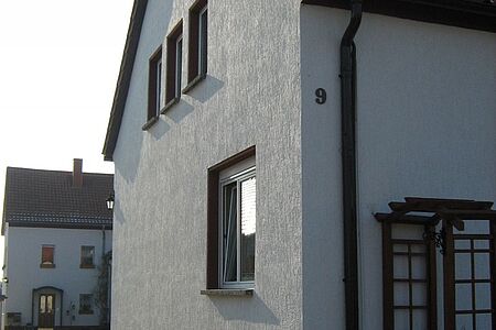 Großes Einfamilienhaus mit weißer Fassade vor der Sanierung