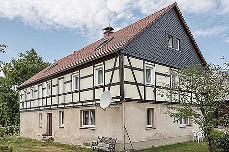 Fachwerkhaus mit pastellgelben Fassadenelementen zwischen den Holzbalken