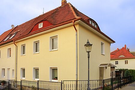 Gelbes Reihenhaus mit sanierter Fassade
