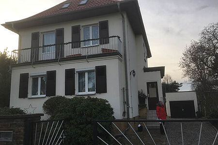 Weiße Villa mit leicht verschmutzter Fassade vor der Sanierung