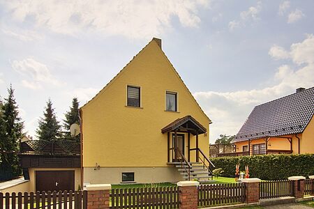 Gelbes Einfamilienhaus mit ebenmäßiger FBS Fassadenbeschichtung