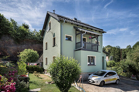 Dreistöckiges Haus mit mintgrüner Klimaschutzfassade