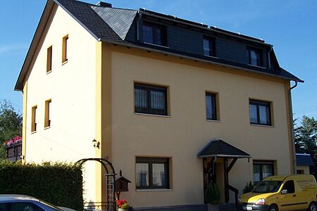Pastellgelbes Doppelhaus mit drei Stockwerken