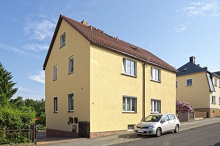Doppelhaus mit drei Stockwerken und gelber Fassade