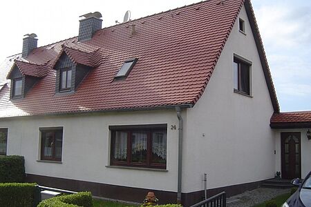 Schmutzig-weißes Zweifamilienhaus vor der Sanierung