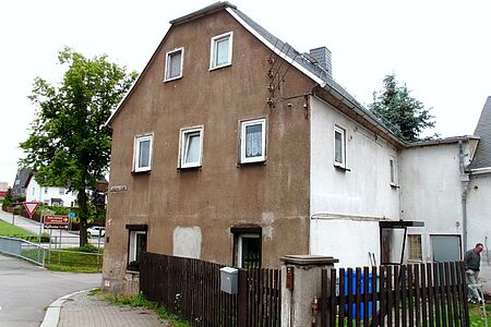 Braune witterungsgeschädigte Hauswand an einer Straßenecke