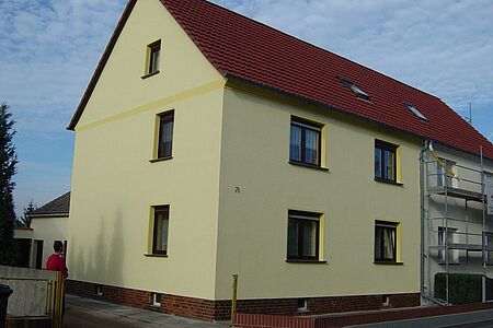 Mehrfamilienhaus mit gleichmäßig pastellgelber Fassade
