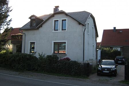 Großes Wohnhaus mit alter Fassade in verblasstem Hellblau
