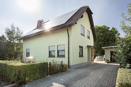 Einfamilienhaus und Garage in hellem Grünton 