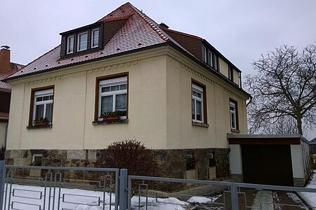 Hellgelbes Wohnhaus mit leicht verschmutzter Fassade