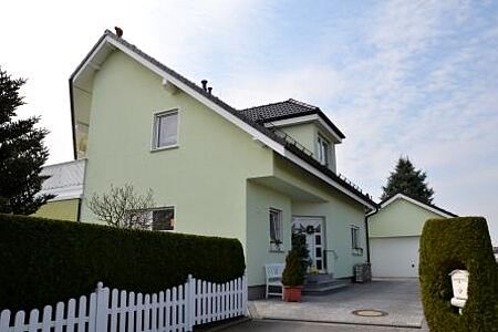 Einfamilienhaus mit schiefem Dach und mintgrüner Fassade