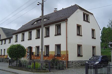 Reihenhaus mit weißer Fassade und Walmdach