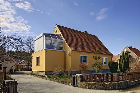 Orangenes Haus mit verglastem Balkon