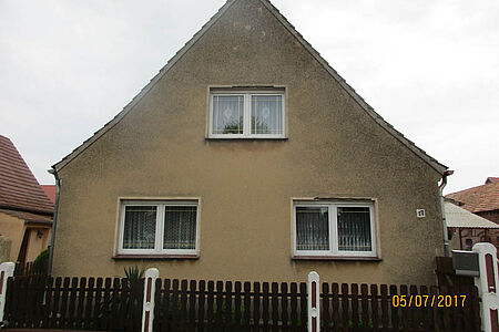 Wohnhaus mit braun verputzter und leicht verwitterter Fassade
