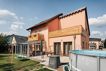 Zweifamilienhaus mit Balkon, Terrasse und strahlender, apricotfarbener Fassade