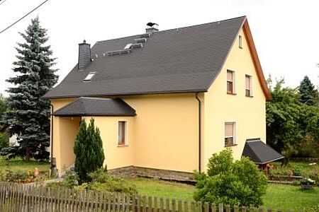 Einfamilienhaus mit heller Fassade und Garten rundherum 