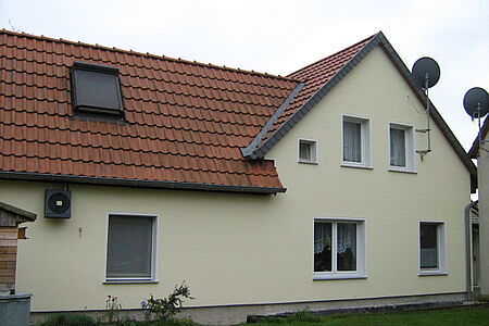 Haus mit ebenmäßigem Putz in Pastellgelb