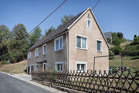 Beige verputztes Wohnhaus nach der Fassadensanierung