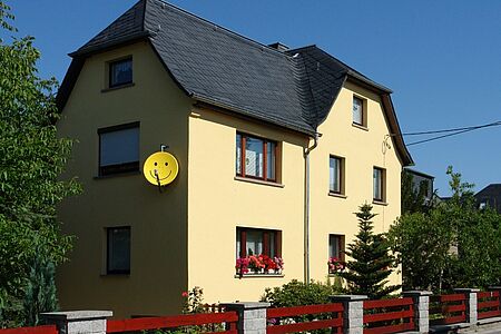 Haus mit drei Stockwerken und gelber Fassade