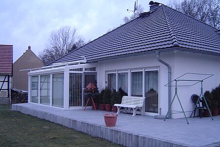 Bungalow mit Walmdach und weißer Fassade