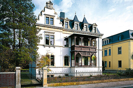 Weiße Stadtvilla mit Holzbalkonen