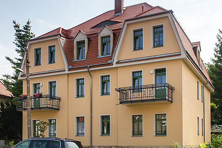 Saniertes Haus mit schmiedeeisernen Balkonen und Erkern