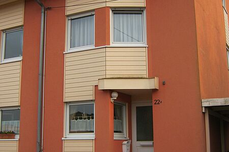 Mehrfamilienhaus mit Vertäfelung vor der Fassadensanierung