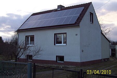 Zweifamilienhaus mit verschmutzter hellblauer Fassade