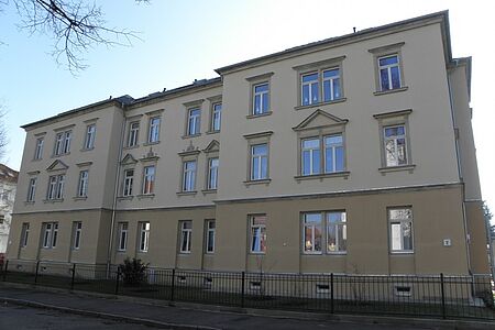 Sanierter Altbau mit Anstrich in verschiedenen Grüntönen