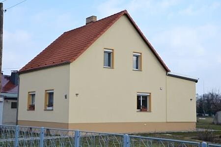 Hellgelbes Wohnhaus mit Vordach und neuer Fassade