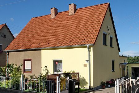 Einfamilienhaus mit zweifarbiger Fassade in Pastellgelb und Braun