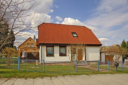 Gelbes Haus mit Walmdach und frischer Fassadenbeschichtung