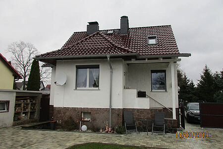 Einfamilienhaus mit Stein-Fundament und Fassade in schmutzigem Weiß